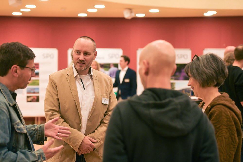 Projektleiter Sven Horn (2. vl) im Gespräch mit Besucher:innen des Infomarkts.